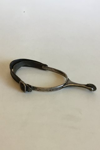 Spur of silver and leather strap.